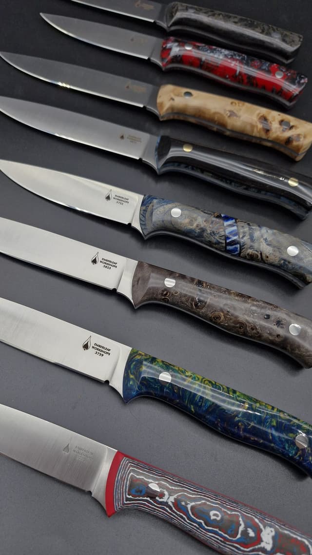 Eight knives in a row, each with a different handle material