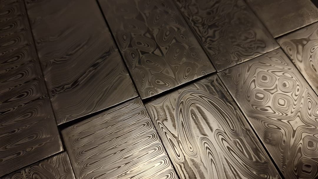 Etched pattern-welded damascus billets laid out on the bench
