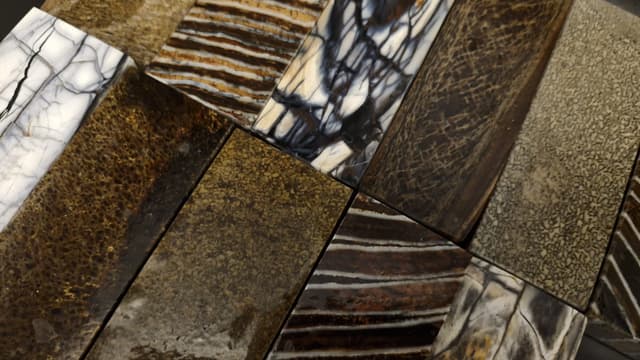 A spread of handle-material slabs: mammoth, stabilised woods and resins