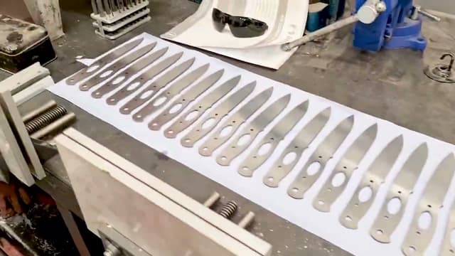 A row of steel blade blanks laid out on the bench