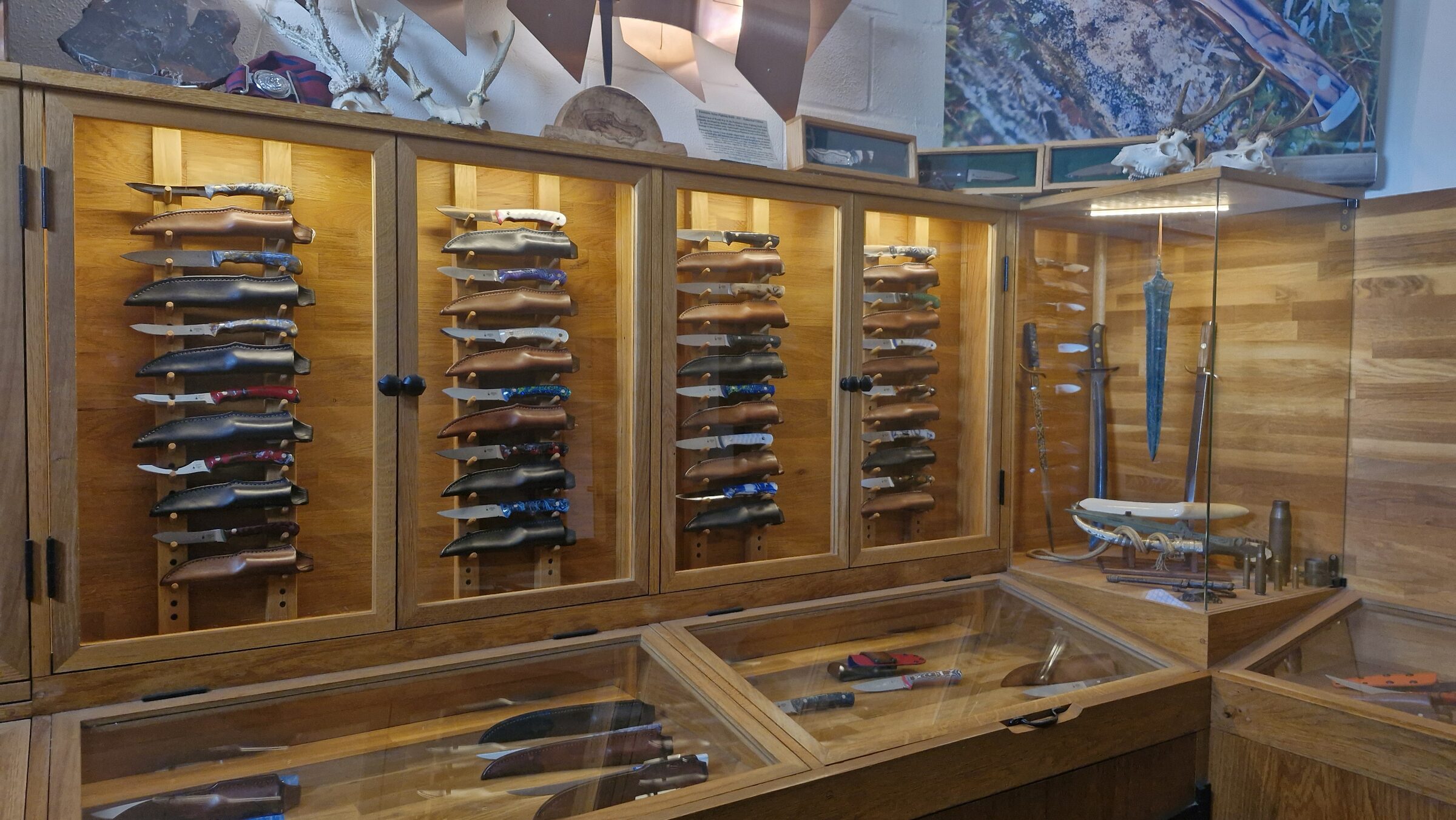 The Emberleaf showroom — oak cabinets and wall racks filled with custom knives