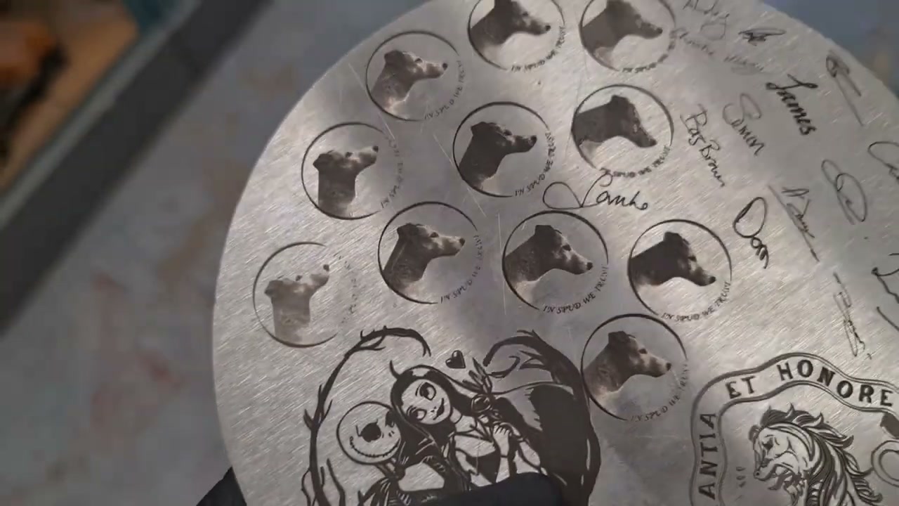 Steel disc laser-engraved with photoreal dog portraits and the team's signatures